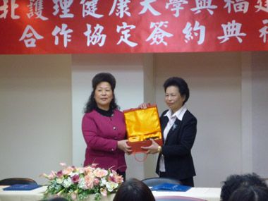 黃校長（右）與姜院長（左）雙方姐妹校互贈禮物。